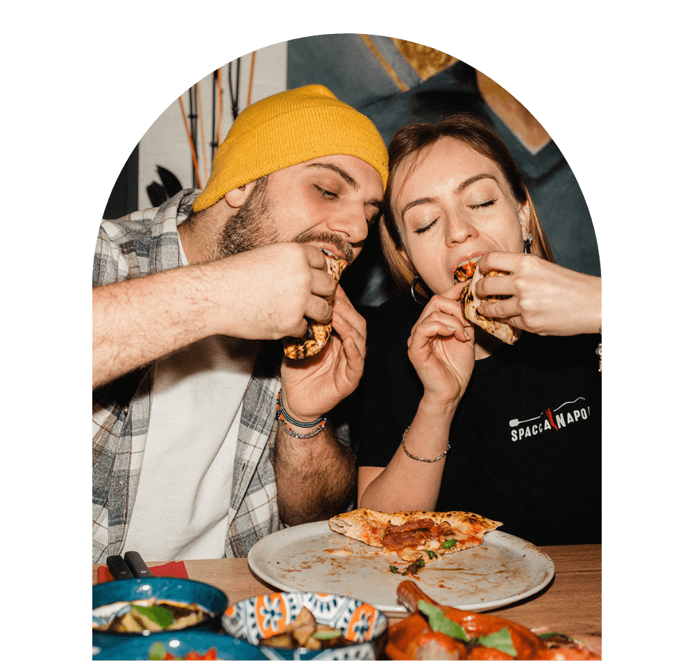 Zwei Gäste essen Pizza bei Spaccanapoli